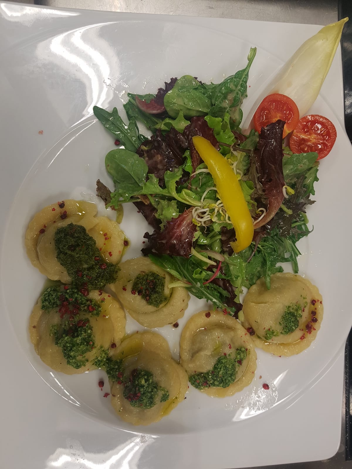 Vegetarisches Gericht mit gefüllter Pasta und Salat